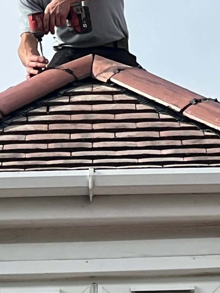 This is a photo of one of the operatives of Dartford Roofing Repairs installing new ridge tiles