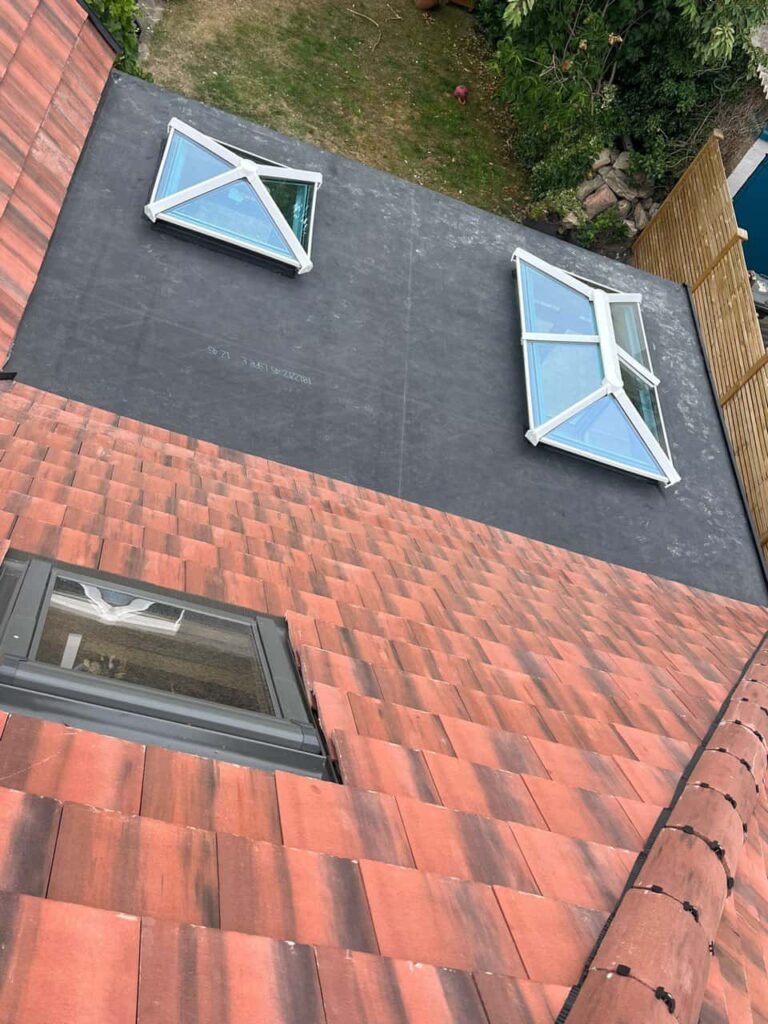 This is a photo taken from the roof ridge looking down a tiled pitched roof on to a flat roof. Works carried out by Dartford Roofing Repairs